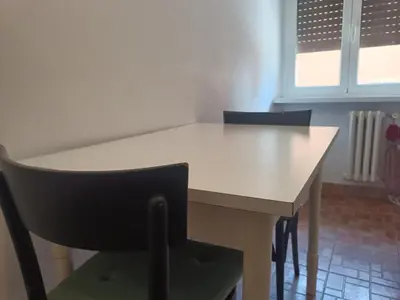 a white table and chairs in a room with a window at Beauty apartment in the green, direct link with center in Rome