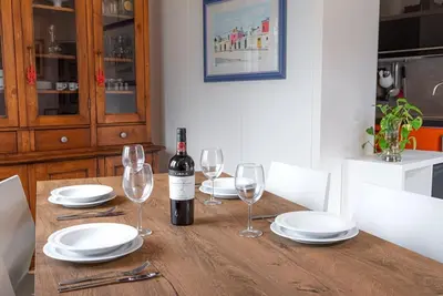 a wooden table with a bottle of wine and glasses at Lungotevere Testaccio Rooftop in Rome