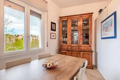 a dining room with a wooden table and a window at Lungotevere Testaccio Rooftop in Rome
