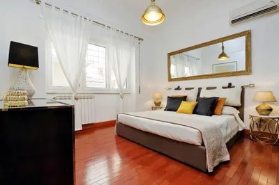 a bedroom with a large bed and a mirror at St Peter 1- Pretty Cozy Apartment (50m from metro) in Rome