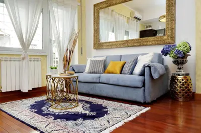 a living room with a blue couch and a mirror at St Peter 1- Pretty Cozy Apartment (50m from metro) in Rome