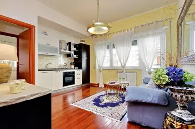 a kitchen and a living room with a blue couch at St Peter 1- Pretty Cozy Apartment (50m from metro) in Rome
