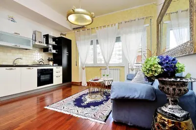 a living room with a blue couch and a kitchen at St Peter 1- Pretty Cozy Apartment (50m from metro) in Rome