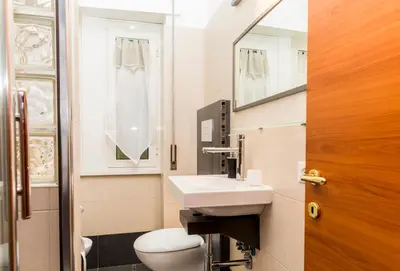 a bathroom with a sink and a toilet and a mirror at S. Peter 2 - Apartment with garden -50m from metro in Rome