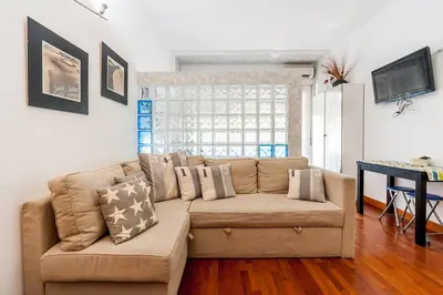 a living room with a brown couch and a desk at St. Peter - Loft at 50m from Metro (up to 4) in Rome