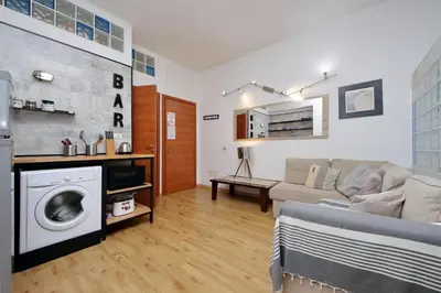 a living room with a couch and a washing machine at St. Peter - Loft at 50m from Metro (up to 4) in Rome