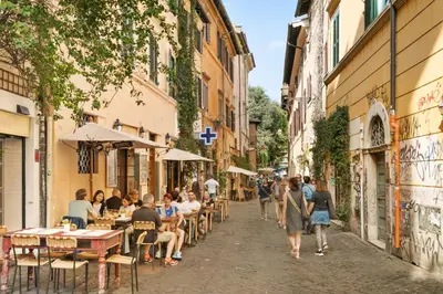a group of people walking down a street with buildings at Luxury apartment in Trastevere in Rome