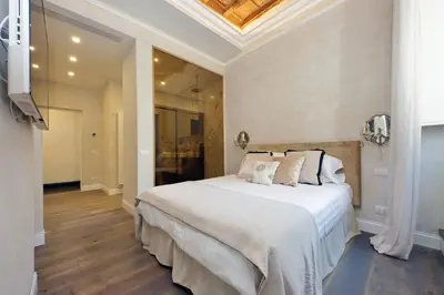 a bedroom with a large white bed with a ceiling at Luxury apartment in Trastevere in Rome