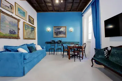 a living room with a blue couch and a table at A 2 passi da Piazza di Spagna in Rome