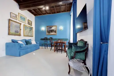 a living room with a blue couch and chairs at A 2 passi da Piazza di Spagna in Rome