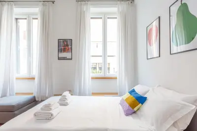 a white bedroom with a bed and a couch at Flaminio Historic Charm and Modern Flair in Rome