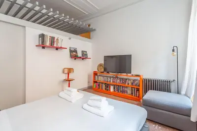 a bedroom with a bed and a tv and a couch at Flaminio Historic Charm and Modern Flair in Rome