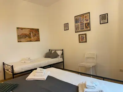 a room with two beds and a chair at Casa Arcangela by GHOR in Rome
