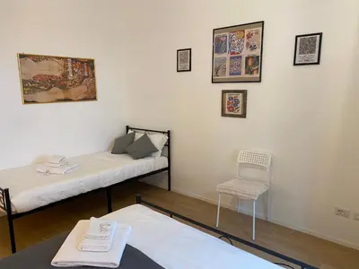 a room with two beds and a chair at Casa Arcangela by GHOR in Rome