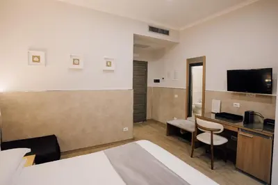 a hotel room with a bed and a desk with a television at Casa Mirabilia in Rome