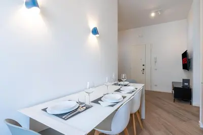 a white dining room with a white table and chairs at [15 minutes from the centre] Free Wi-Fi & A/C in Rome