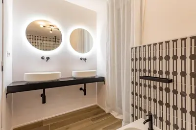 a bathroom with two sinks and a mirror at Daplace - Elena Apartment in Rome