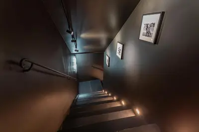 a hallway with stairs with lights on the wall at Daplace - Elena Apartment in Rome