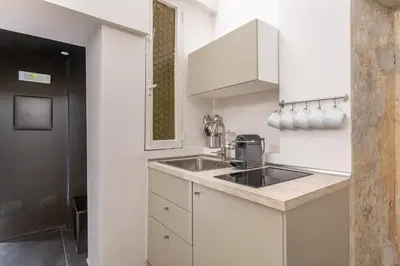 a kitchen with white cabinets and a sink at Daplace - Elena Apartment in Rome