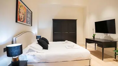 a bedroom with a bed and a desk and a television at Pinciana - Veneto - Marilyn House in Rome