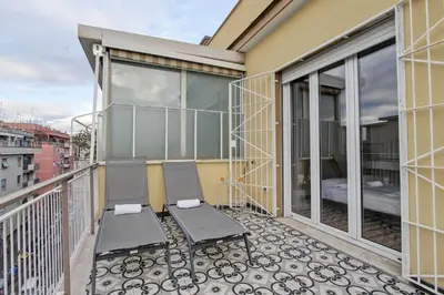 a balcony with two chairs and a bed at Design Monteverde Flat in Rome