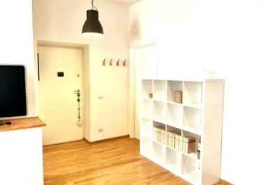 a room with a white book shelf and a television at The Fontana Carlotta at Garbatella in Rome