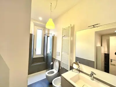a bathroom with a toilet and a sink and a mirror at The Fontana Carlotta at Garbatella in Rome