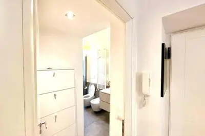 a white bathroom with a toilet and a mirror at The Fontana Carlotta at Garbatella in Rome