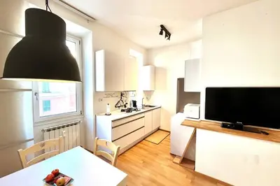 a kitchen with a dining table and a large television at The Fontana Carlotta at Garbatella in Rome