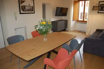 a dining room table with a vase of flowers and chairs at Nesty Margana House in Rome