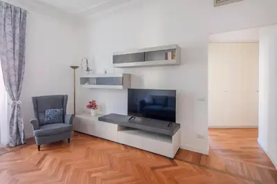 a living room with a television and a chair at Appartamento “La Palma nel Cortile” in Rome