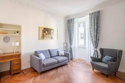 a living room with a couch and a chair at Appartamento “La Palma nel Cortile” in Rome
