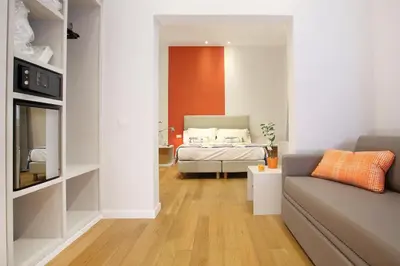 a bedroom with a bed and a couch in a room at Sofia's Suites Guesthouse in Rome