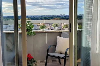 a balcony with a chair and a view of the city at Terrace Mariù Apartment in Rome