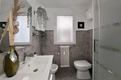 a bathroom with a white sink and a toilet at Terrace Mariù Apartment in Rome