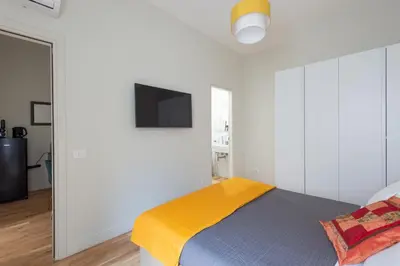 a bedroom with a bed with a tv on the wall at Cattaneo monti delizioso e nuovissimo appartamento in Rome