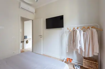 a bedroom with a bed and a tv on a wall at Cattaneo monti delizioso e nuovissimo appartamento in Rome