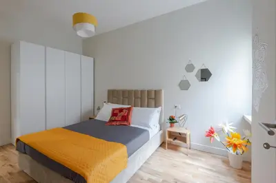 a bedroom with a bed with an orange blanket at Cattaneo monti delizioso e nuovissimo appartamento in Rome