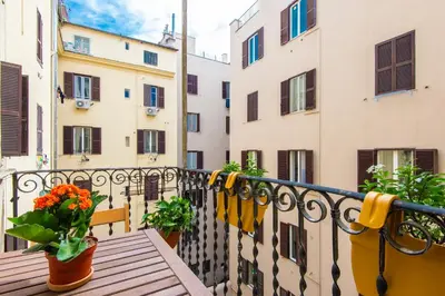 a balcony with two pots of flowers and buildings at Cattaneo monti delizioso e nuovissimo appartamento in Rome