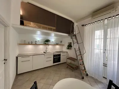 a kitchen with white cabinets and a ladder at Vacanze Romane in Rome