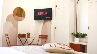 a bedroom with a bed and a tv on the wall at Vera Roma Suite&Apartment - Charming 3 bedroom apt - 20min walk from Colosseum in Rome