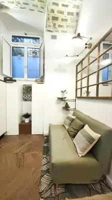 a living room with a green couch in a room at Vera Roma Suite&Apartment - Charming 3 bedroom apt - 20min walk from Colosseum in Rome