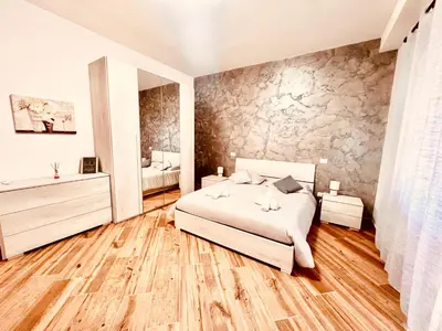 a bedroom with a white bed and a stone wall at 15 Min. Colosseo 1 - Casa di Giò in Rome