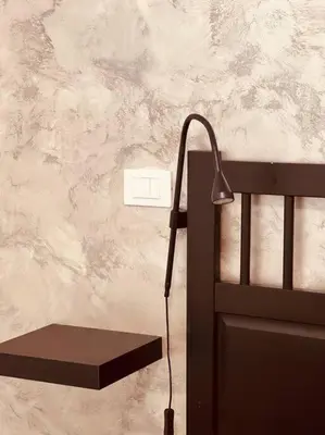 a lamp next to a chair with a wall at 15 Min. Colosseo 1 - Casa di Giò in Rome