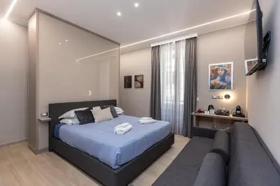 a bedroom with a large bed and a couch at IRON Luxury Rooms in Rome