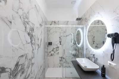 a white bathroom with a sink and a mirror at IRON Luxury Rooms in Rome