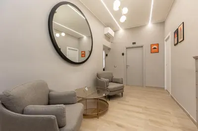 a living room with a mirror and chairs and a table at IRON Luxury Rooms in Rome