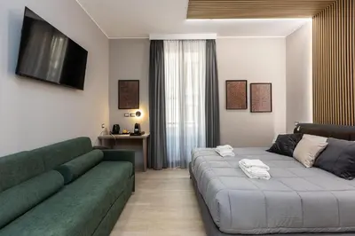 a living room with a green couch and a television at IRON Luxury Rooms in Rome