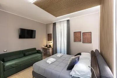 a hotel room with a bed and a couch at IRON Luxury Rooms in Rome