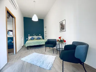 a bedroom with a bed and two chairs and a table at San Lorenzo 47 Loft in Rome